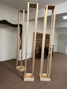 three tall wooden poles in an empty room