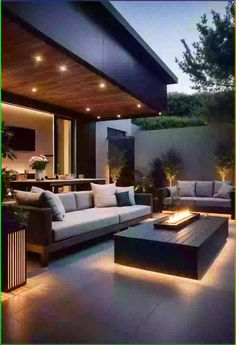 an outdoor living area with couches, tables and fire pit in the middle of it