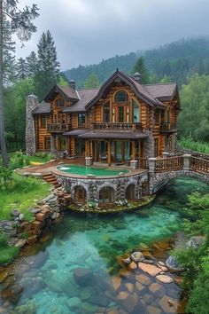 a large wooden house sitting on top of a lush green hillside next to a river