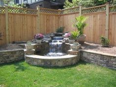 a backyard with a small waterfall in the middle