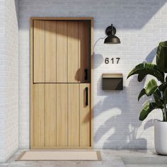 a white brick wall with a wooden door and mailbox next to a potted plant