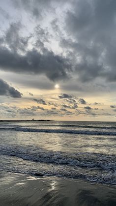 the sun is shining through clouds over the ocean