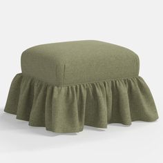 a green ottoman with ruffles on the top and bottom, in front of a white background