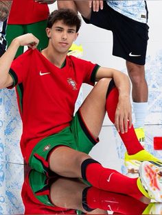 a young man sitting on top of a soccer ball