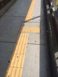 the sidewalk is lined with yellow and blue barriers