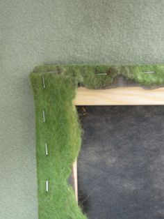 a frame made out of grass with pins on it