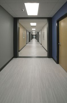 an empty hallway with blue walls and white floors