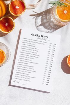 a table topped with oranges and glasses next to a paper that says guess who