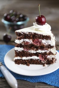 a slice of chocolate cake with cherries on top