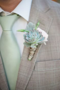 a man wearing a suit and tie with a boutonniere on his lapel