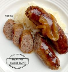 two sausages and sauerkraut on a white plate