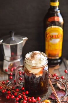 hot chocolate in a mason jar with whipped cream and cranberries on the table