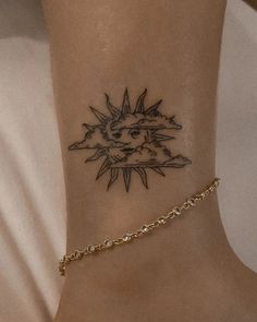 a woman's foot with a sun tattoo on the side of her ankle,