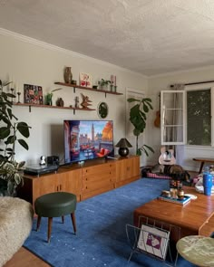 a living room filled with furniture and a flat screen tv on top of a wooden table