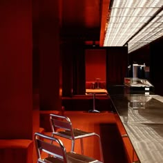 a chair and table in a room with red lighting on the walls, along with other furniture