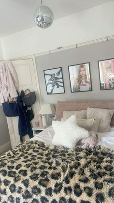 a bedroom with pictures on the wall and a leopard print bed spread in front of it