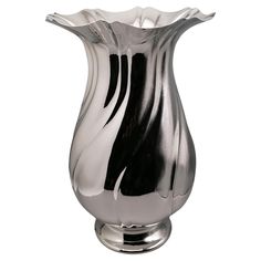 a silver vase sitting on top of a metal stand with black and white stripes in it