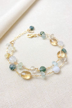 This artisan-crafted, multi-gemstone style bracelet boasts striking green gems, including aquamarine and moss agate, paired perfectly with lustrous golden quartz gems.  Rainbow moonstone adds an ethereal glow.

This is a timeless accessory perfect for weddings and other special occasions, as well as elevating your everyday style.

Handcrafted in southeastern Georgia. Making Crystal Bracelets, Gold Bracelets With Natural Stones And Mineral Crystal, Green Citrine Jewelry With Gemstone Accents, Green Citrine Jewelry With Natural Stones, Green Bracelets With Gemstone Accents As Gift, Green Gemstone Bracelet Jewelry, Green Gemstone Accented Bracelet, Green Gemstone Accents Bracelet, Green Gemstone Accent Bracelet