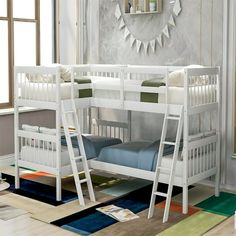 a white bunk bed with two sets of ladders on the bottom, and another set of beds below