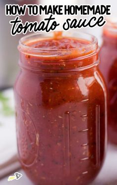 two jars filled with sauce sitting on top of a table