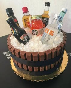 a cake made to look like an ice bucket with liquor bottles in it and snow on the bottom