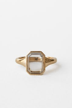 an antique yellow gold ring with a white diamond in the center, on a white background