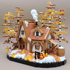 a house made out of legos with lots of yellow and white decorations on the roof