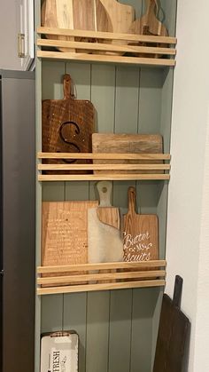 some wooden cutting boards are sitting on shelves