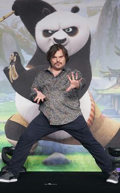 a man standing in front of a giant panda bear