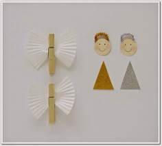 three pieces of paper are arranged on a white surface, with gold and silver decorations