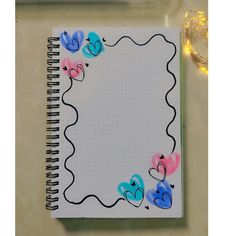 a spiral notebook with hearts drawn on it