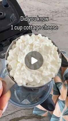 someone is holding a knife over a bowl of cottage cheese in front of an open air fryer