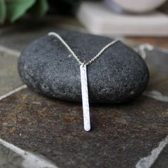 This is a simple sterling silver hammered bar necklace that makes a perfect gift for a teacher, hostess, or loved one. And, it looks great by itself or layered with other chains. Here are the details: I saw the 1 1/4" bar from thick rectangular sterling silver wire and hammer for texture. The finished length is available in 16 or 18 inches. Chain style may vary, depending on what I have on hand...although it will always be sterling silver. Silver Sterling Silver Bar Necklace With Rectangular Pendant, Silver Bar Necklace Perfect As A Gift, Gift For A Teacher, Bar Necklaces, Vertical Bar Necklace, Vertical Bar, Hammered Silver, Bar Necklace, Silver Wire