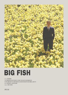 a man in a suit standing in a field of flowers