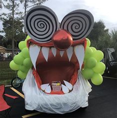 an inflatable monster with large eyes and mouth is on display at a street fair