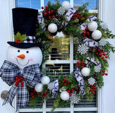 a christmas wreath with a snowman wearing a top hat and bow tie on the front door