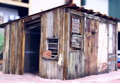 an old outhouse made from wooden boards with doors open and shutters closed on the outside