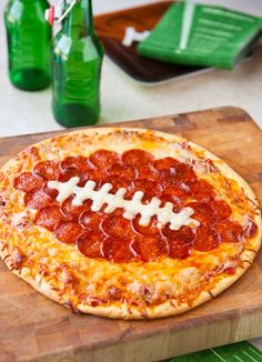 a pepperoni football pizza on a cutting board