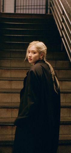 a woman standing in front of some stairs