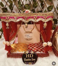 an elaborately decorated table with red and gold decorations on it, along with a sign that says hd boutiquene