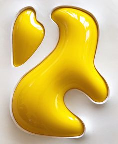 the letter s is made up of yellow liquid or acrylic paint on a white surface