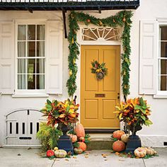 a yellow door and some pumpkins in front of it