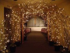 an archway decorated with lights and potted plants