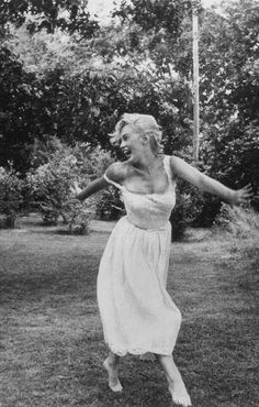 an old photo of a woman jumping in the air with her arms spread wide open