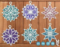 paper snowflakes are hanging on a wooden background with the words svng eps dxf