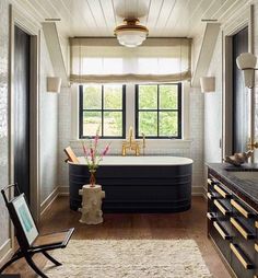 a bathroom with a large tub and wooden floors