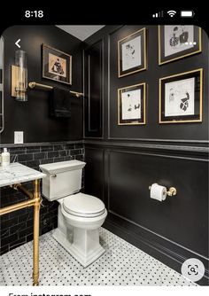 a black and white bathroom with gold trim on the walls, toilet and sink in it