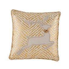 a gold and white pillow with a deer on it