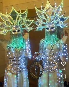 two women dressed in costumes with lights on them