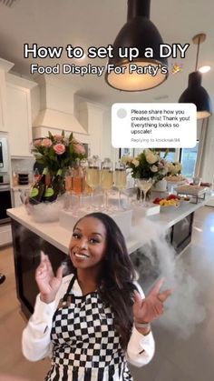 a woman standing in front of a kitchen counter holding her hands up to the camera